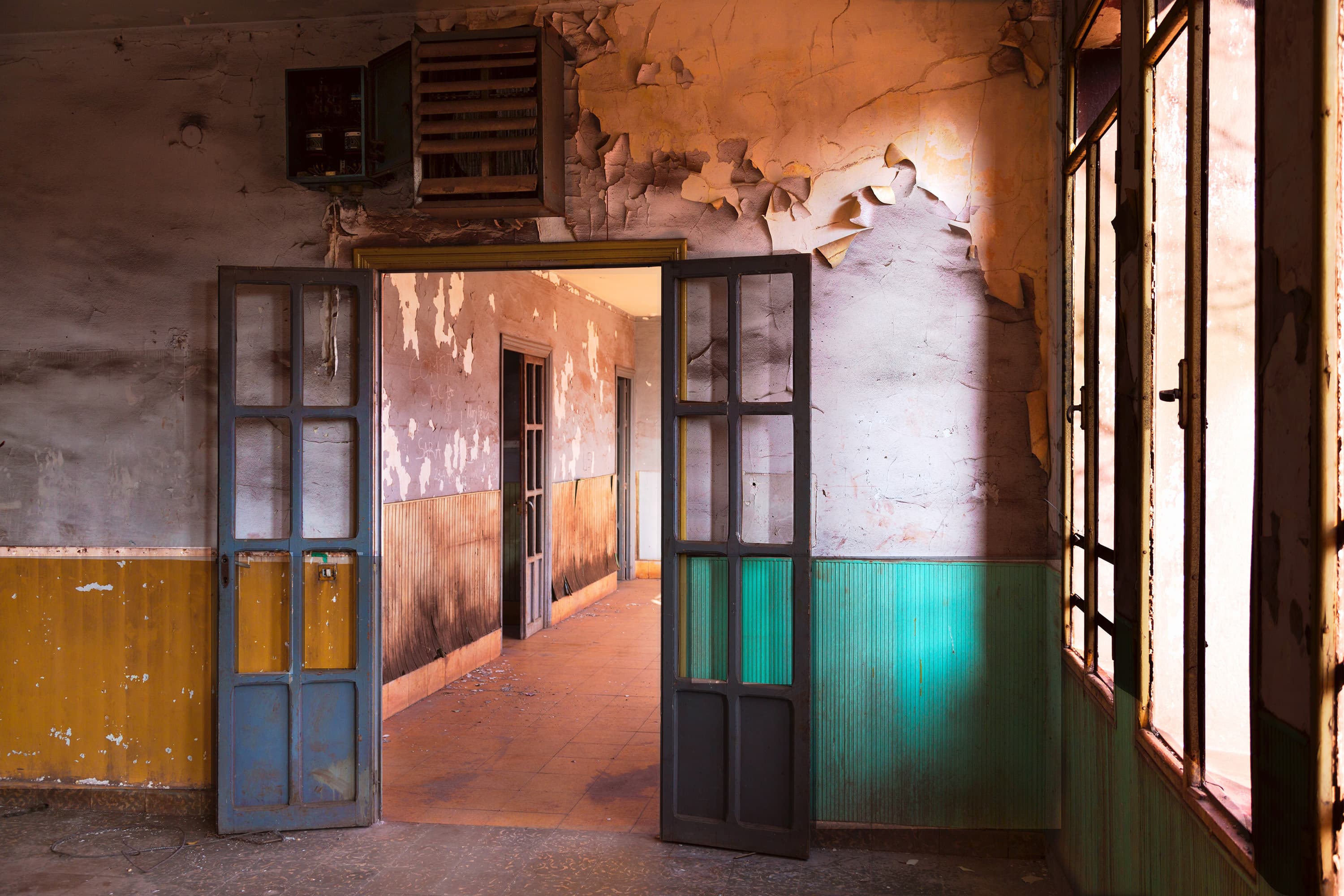 Doorway in building where paint on walls is pealing