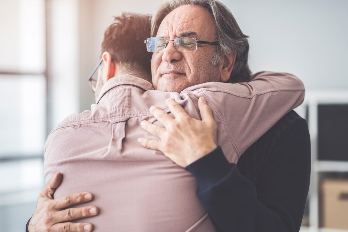 Two people (father and son) embracing