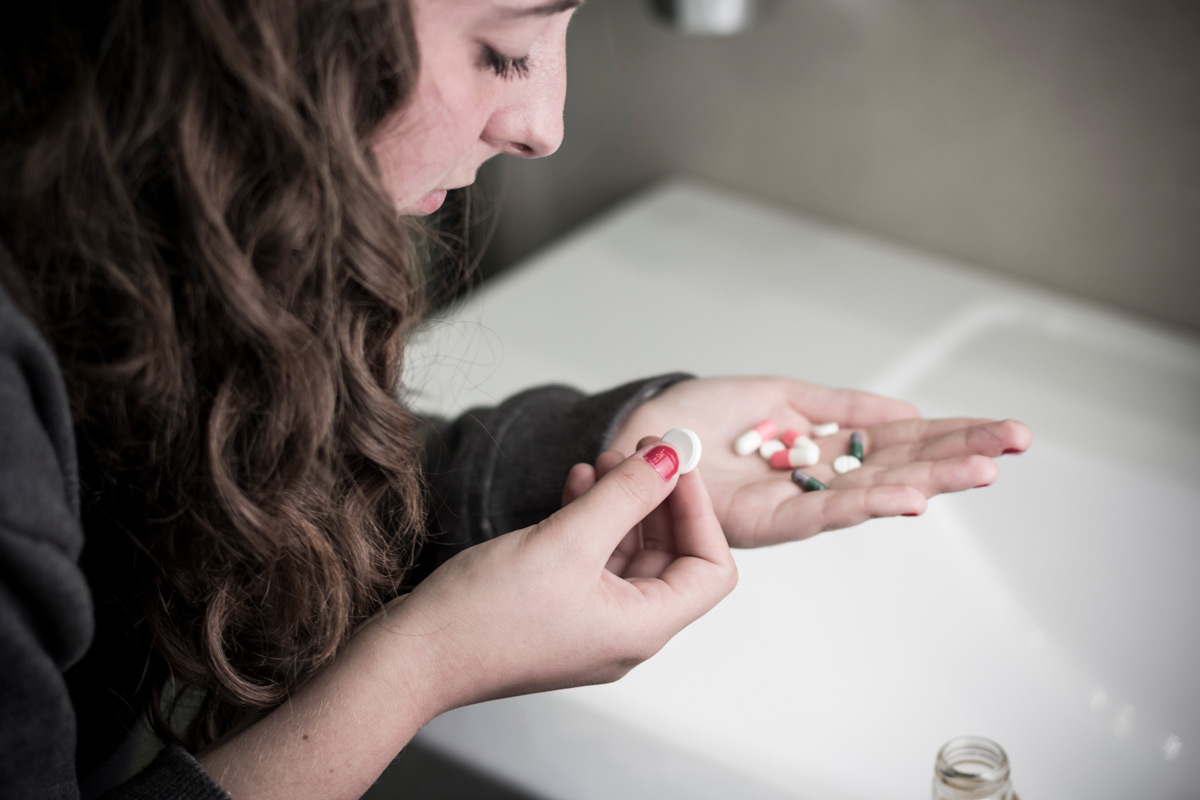 Person looking at pills in hands