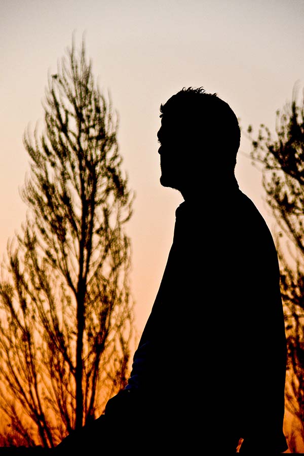 Man in silhouette with trees in background